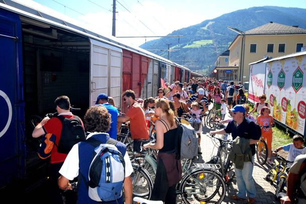 Viele Menschen und Kinder am Bahnhof in Lienz mit Fahrrädern beim Verladen der Fahrräder in den Zug